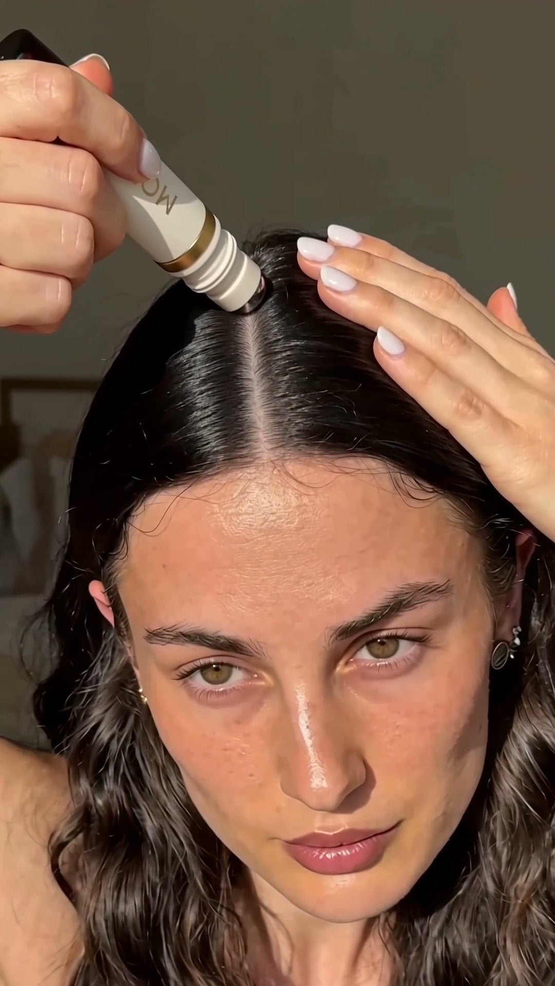 Woman holding a clean scalp part for the roller