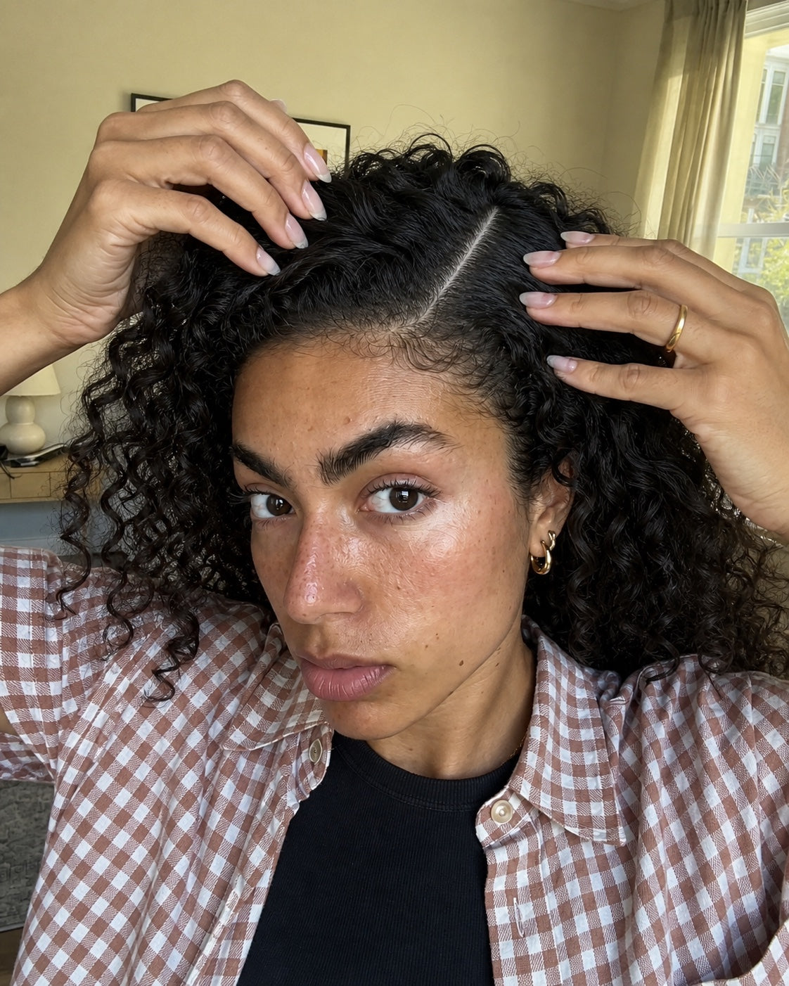 Woman using both hands to open a clean, dry scalp part before application